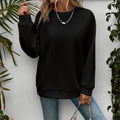 Black relaxed crewneck sweatshirt with raglan sleeves, front view