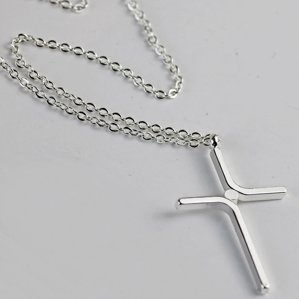 Silver tone cross pendant on a chain, close view