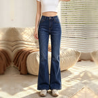 Dark indigo high waist flare jeans worn with a white crop top, front view