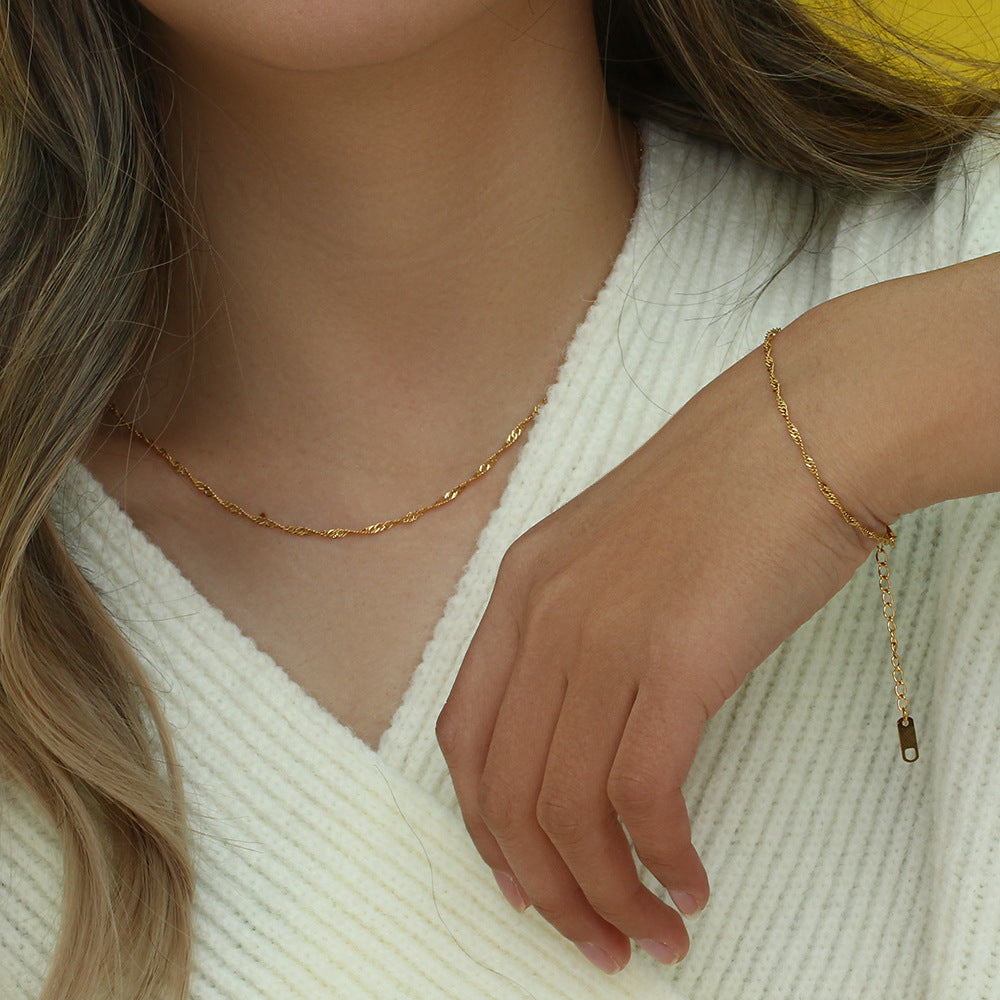 Gold tone chain necklace and bracelet worn together