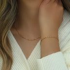 Gold tone water wave chain bracelet worn on the wrist