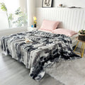 Charcoal gradient bubble faux fur throw spread across a bed (supplier photo)
