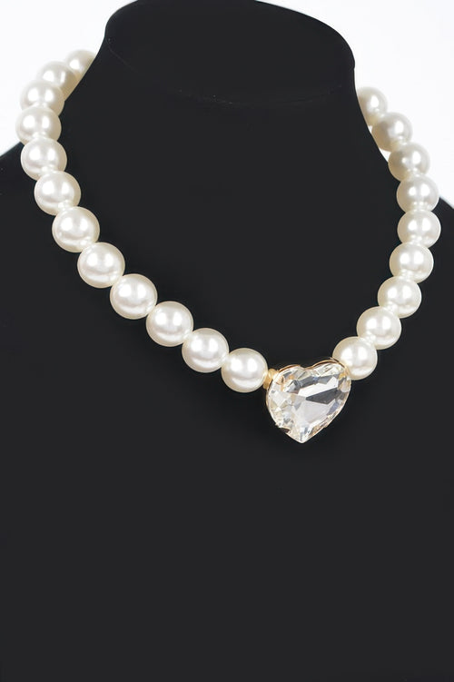 Close up of the faux pearl necklace and faceted heart stone