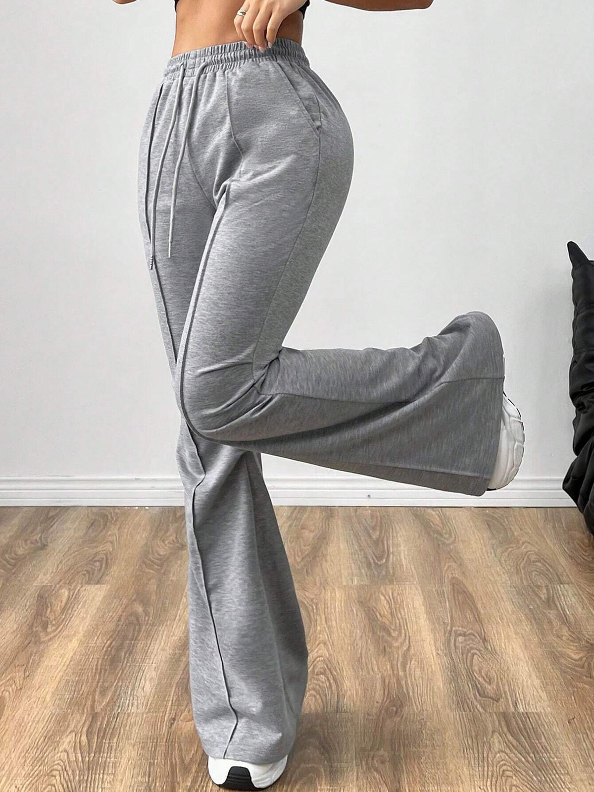 Gray flare sweatpants in motion, side view